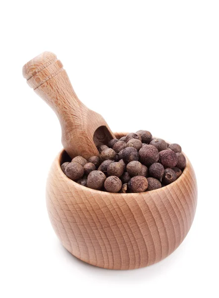 Trä scoop i skål full av kryddpeppar isolerad på vit — Stockfoto