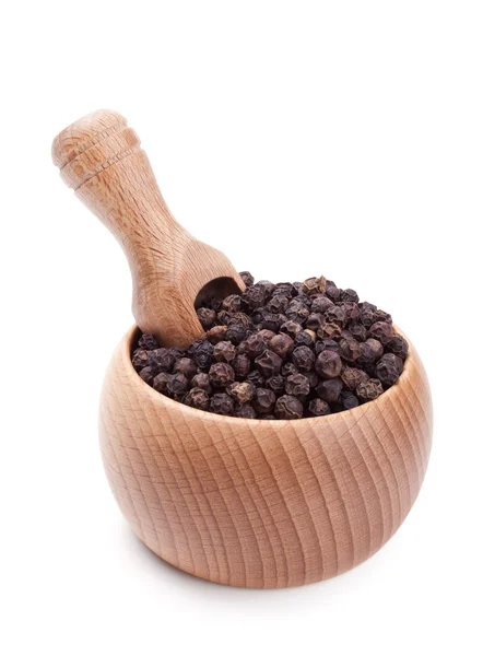 Cuchara de madera en bol lleno de granos de pimienta negra — Foto de Stock