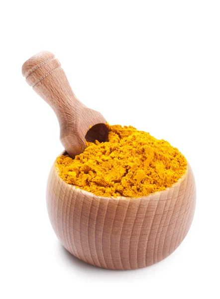 Wooden scoop in bowl full of dry turmeric — Stock Photo, Image