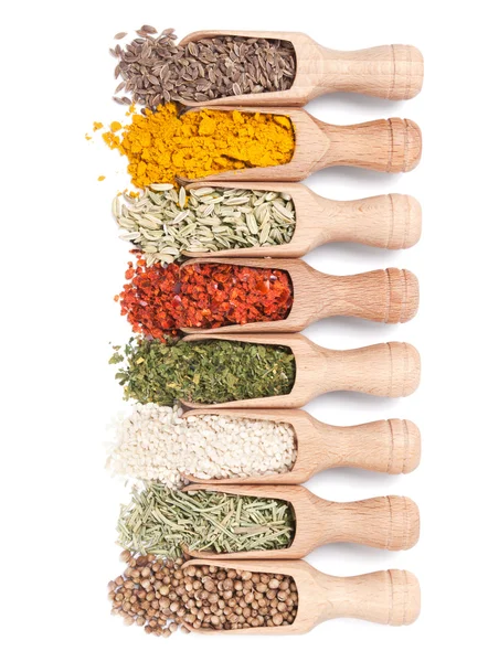 Wooden shovels with different spices scattered from them — Stock Photo, Image