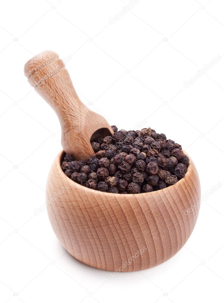 Wooden scoop in bowl full of black peppercorn