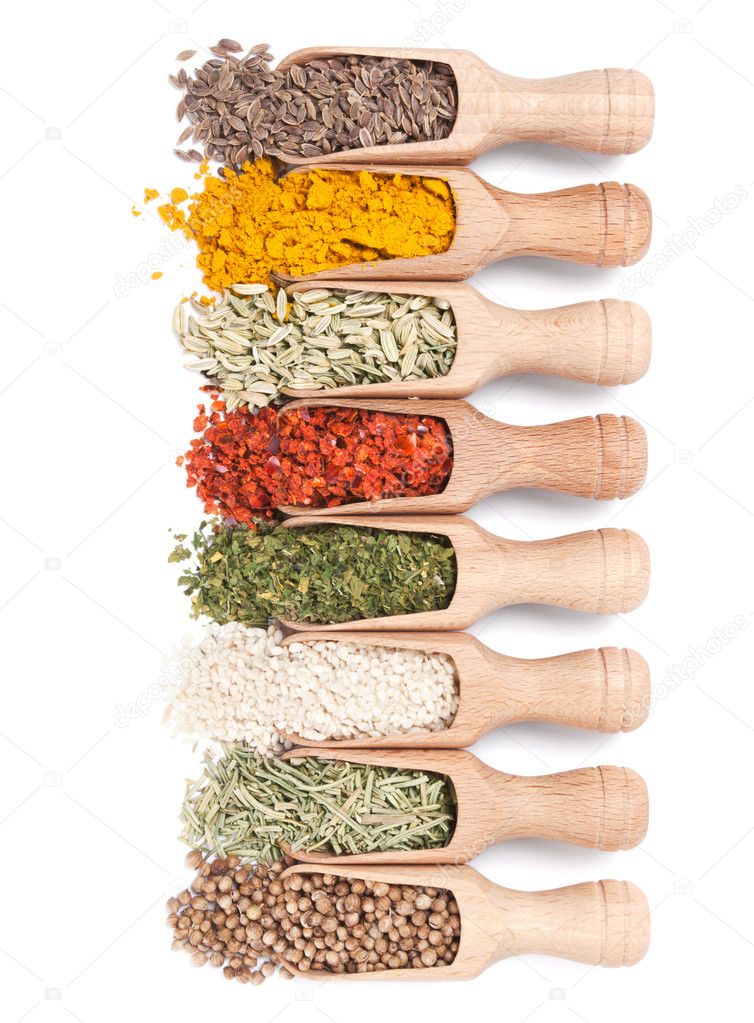 Wooden shovels with different spices scattered from them