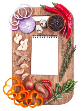 Open notebook and fresh vegetables on an old wooden cutting boar clipart