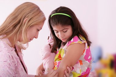 Doktor vermek enjeksiyon kızın kolu, küçük kız üzerinde.