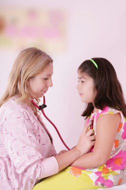 Female doctor examining little girl clipart