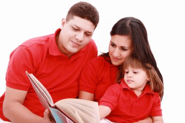 Family sitting on floor reading book at home clipart