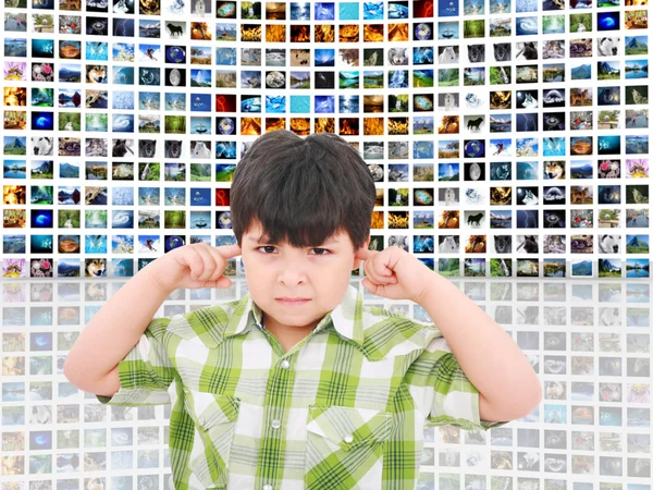 Criança protegendo os ouvidos do barulho alto de tantas telas falando — Fotografia de Stock