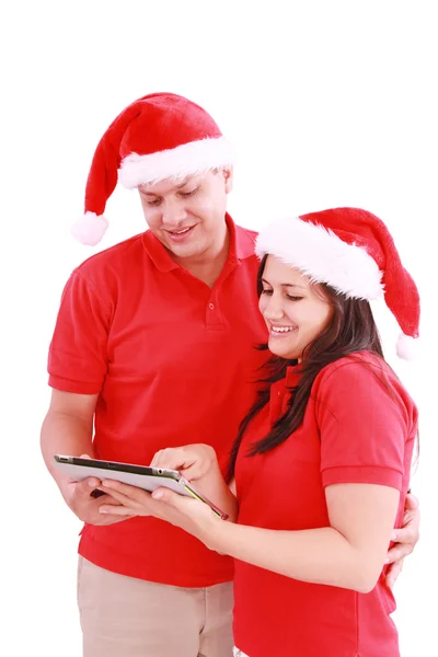 Gelukkige Kerstmis paar op zoek een tablet pc. geïsoleerd op wh — Stockfoto