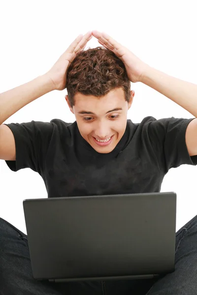 Giovane uomo scioccato con qualcosa che vede sul suo computer portatile — Foto Stock