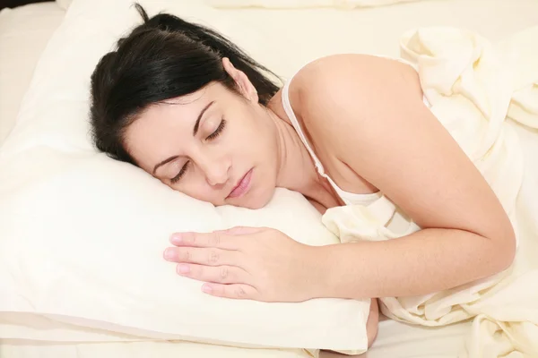 Portret van mooie jonge vrouw slapen op het bed. — Stockfoto