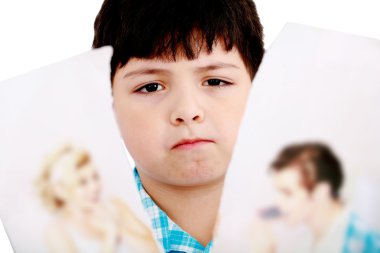 Upset boy standing in front pcture of parents with problems agai clipart