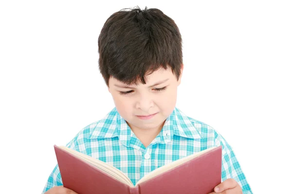 Menino pequeno lendo um livro sobre um fundo branco — Fotografia de Stock