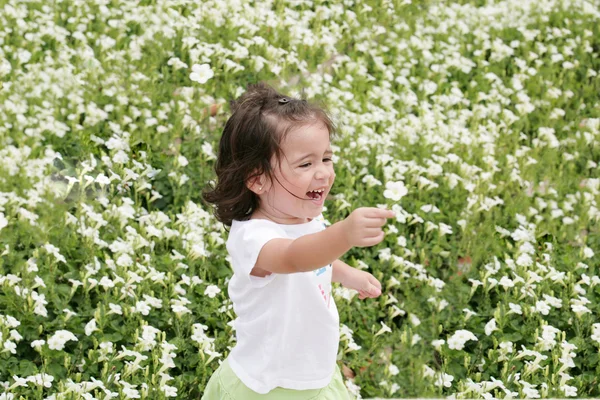 Малышка счастлива в саду цветов — стоковое фото