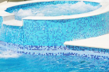 Empty Swimming pool with waterfall jet and jacuzzi in action clipart