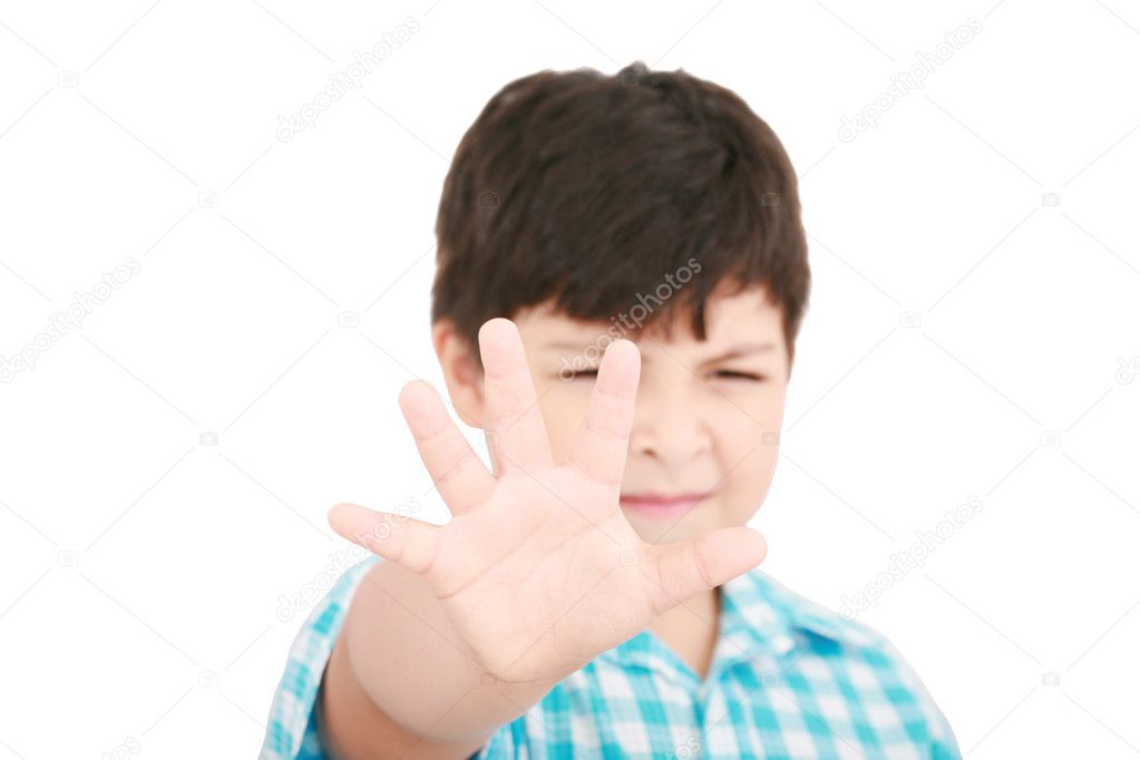 Child looking at camera. Stop signal with his hand. Boy trying