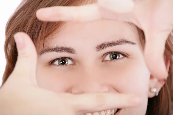 Vrij volwassen vrouw kijken door een frame gemaakt door haar handen. — Stockfoto