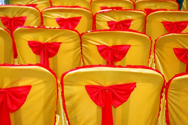 Rows of seats with a golden yellow cover and red tape — Stock Photo, Image