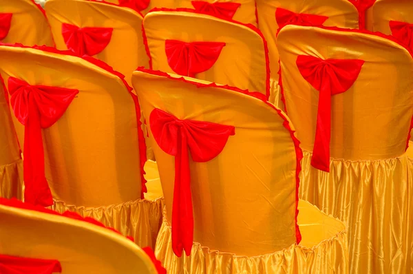 Linhas de assentos com uma capa amarela dourada e fita vermelha — Fotografia de Stock