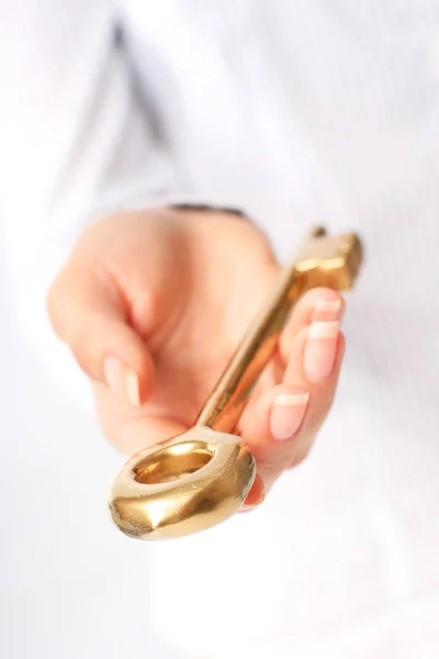 Hand is giving a gold key. — Stock Photo, Image