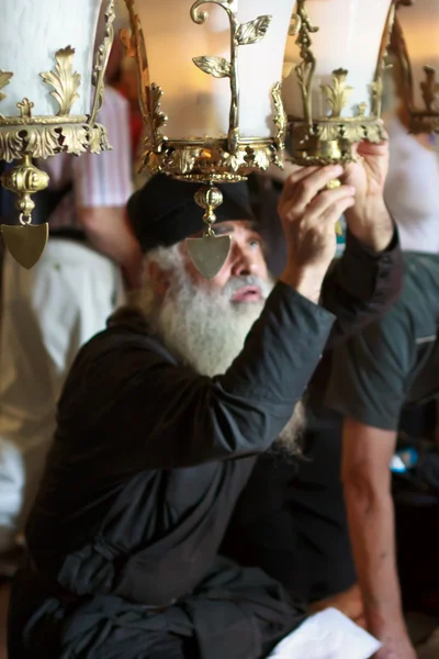 stock image Clergyman is lighting an oil-lamp at midday