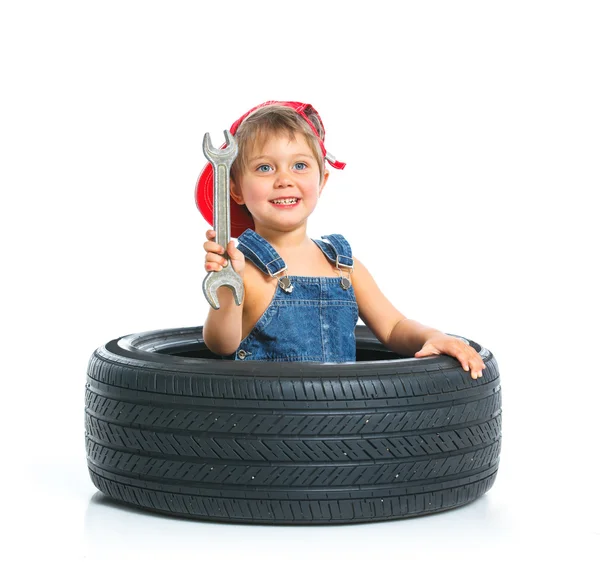 Pequeno mecânico com um pneu — Fotografia de Stock