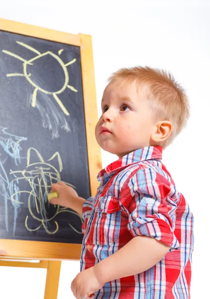 Маленький мальчик рисует на доске — стоковое фото