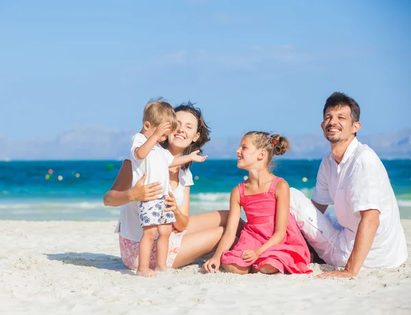 Familie van de vier op tropisch strand — Stockfoto