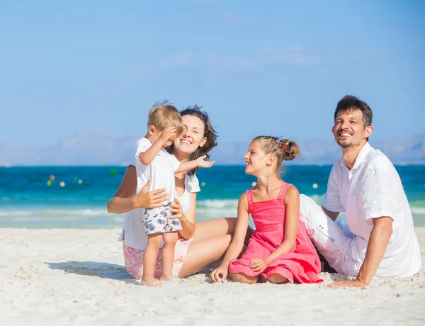 Família de quatro na praia tropical — Fotografia de Stock