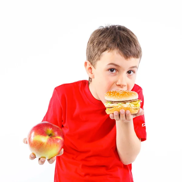Chlapec jíst hamburger. — Stock fotografie