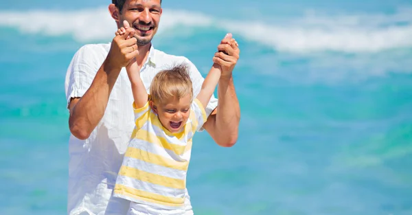 Pai e filho se divertindo na praia — Fotografia de Stock