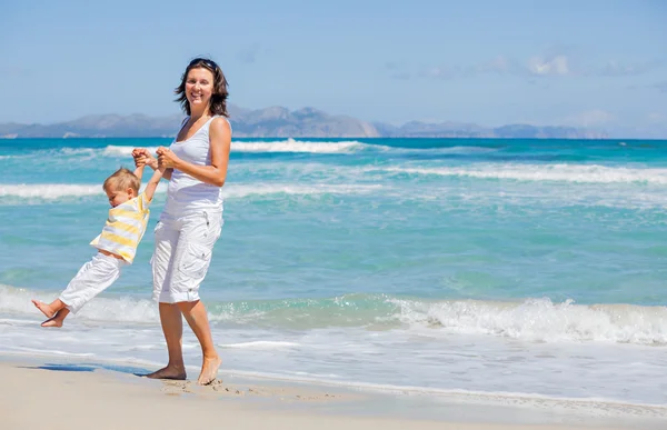 Mãe e filho se divertindo na praia — Fotografia de Stock