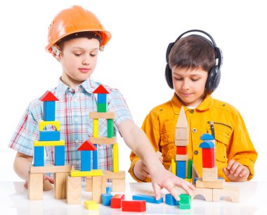 Two smiling little boys is building clipart