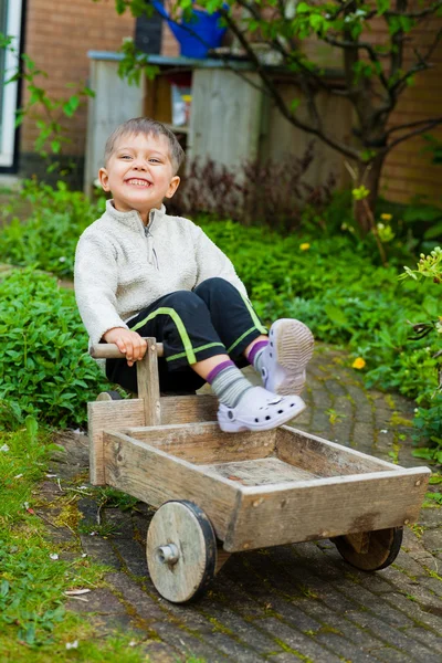 Roztomilý chlapec hraje s hračkou nástroji v zahradě. — Stock fotografie