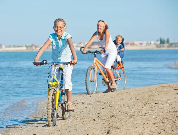 Linda chica con su madre y su hermano montar en bicicleta — Foto de Stock