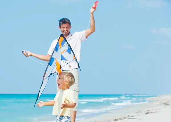 Chlapec s otcem na pláži hraje s drakem — Stock fotografie
