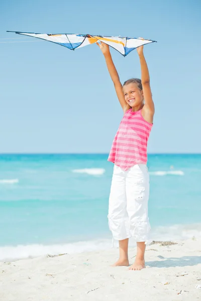 Cute girl on beach playing with a colorful kite — Stock Photo, Image