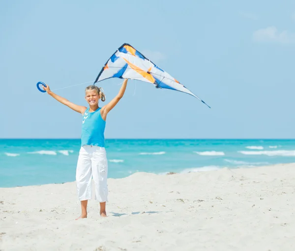 Plaj renkli bir uçurtma ile oynarken sevimli kız — Stok fotoğraf