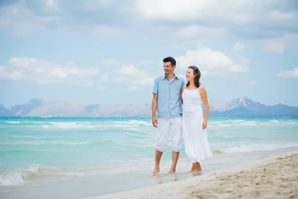 Feliz jovem casal andando na praia — Fotografia de Stock