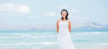 Young woman walking near blue sea.