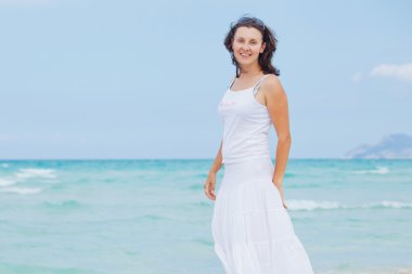 Young woman walking near blue sea.