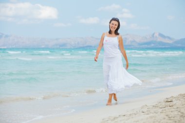 Young woman walking near blue sea.