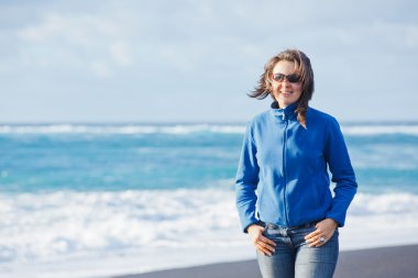 Young woman walking near blue sea.