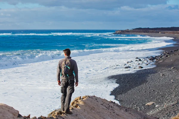 Młody człowiek, piesze wędrówki i patrząc na morze — Zdjęcie stockowe