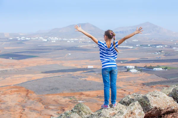 Girl standing on cliff's edge, looking to a sky — Stock Photo, Image