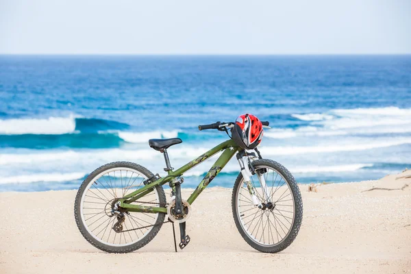 Bicicleta com capacete, ficar na praia . — Fotografia de Stock
