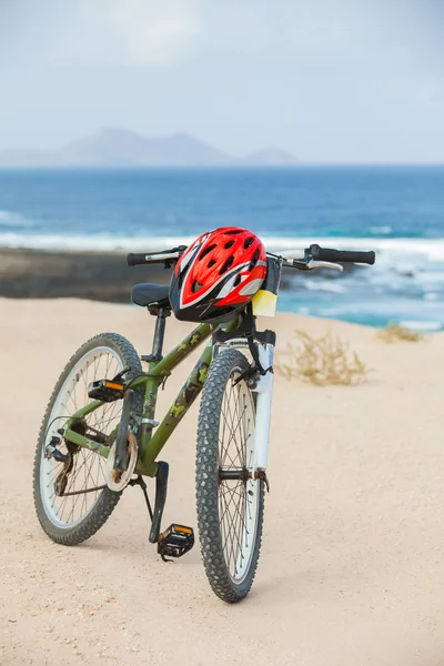 Cykel hjälm, stå på stranden. — Stockfoto