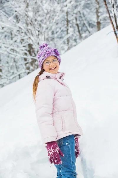Vintern flicka kastar snöboll — Stockfoto