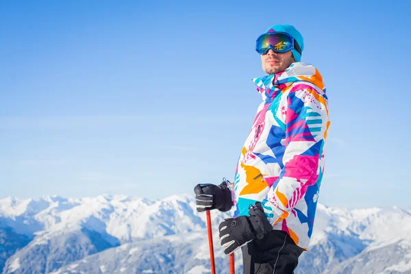 Молодой человек с лыжами и лыжной одеждой — стоковое фото