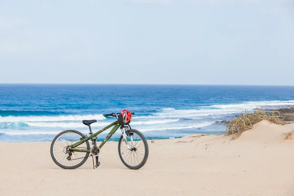 stock image Bicycle with helmet, stand on the beach.