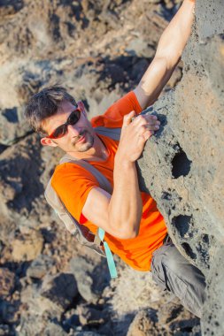 Young man in glasses with backpack climbing clipart